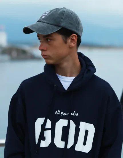 Sudadera azul con capucha para hombre y mujer. Algodón 100%. Con el mensaje “All you need is God”. Producto solidario de Have a God Time